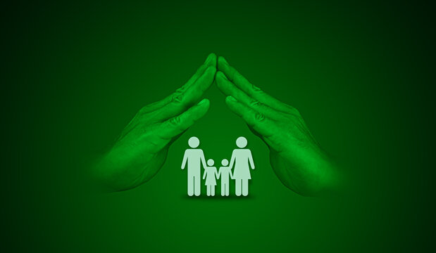 A man's hand shields a family against a green background. The concept of health and life insurance
