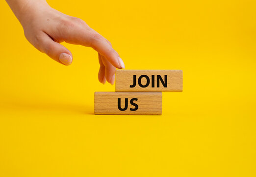 Join us symbol. Concept word Join us on wooden blocks. Beautiful yellow background. Businessman hand. Business and Join us concept. Copy space