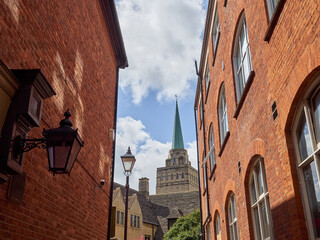 Bulwarks Lane with red brick buildings and the view of the tower and the spire of Nuffield College....