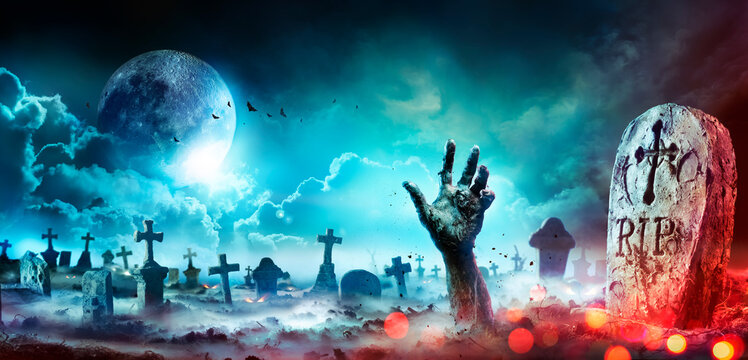 Zombie Hand Rising Out Of A Graveyard At Night With Full Moon
