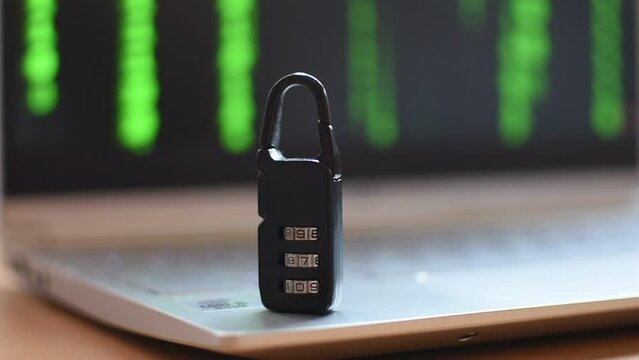 Locked metal padlock on a laptop keyboard over green background. Cyber security, antivirus software concept