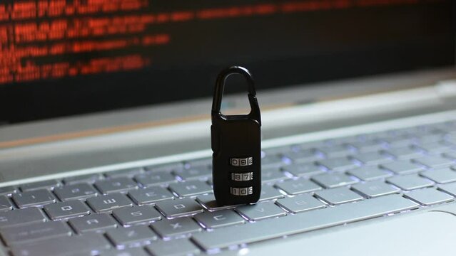 Locked padlock on top of laptop. A red digital pattern is seen on the background 