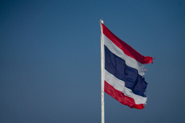The flag of Thailand is hanging on a pole.