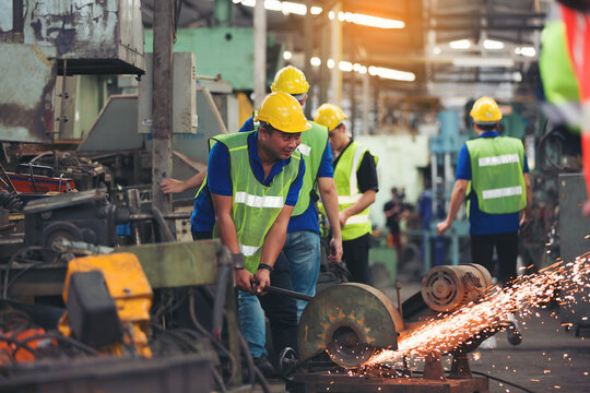 Group Of Asian Male Worker Working With Metal Cutting Saws. Team Of Asian Male Factory Worker Working On Cutting Metal And Steel With Compound Mitre Saw And Circular Blade At The Industrial Factory