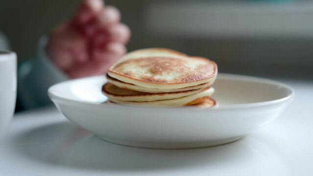 Close-up Of Hot Pancakes. Little Hand Takes Pancake
