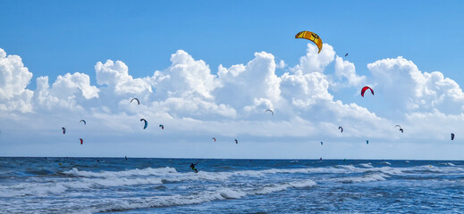 Cometas de Kai Surf en un día soleado y lleno de grandes nubes en una playa española
