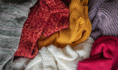 Fototapeta na wymiar Autumn and winter background with knitted colourful sweaters