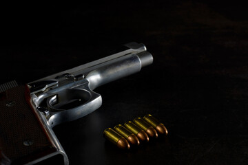 Gun. Semi automatic 9 mm parabellum stainless steel pistol on natural dark background. Low key photography.