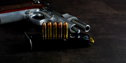 Gun. Semi automatic 9 mm parabellum stainless steel pistol on natural dark background. Low key...