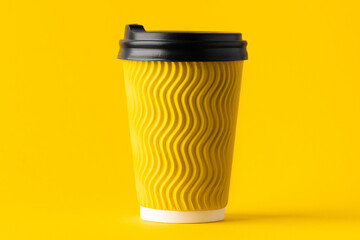 Yellow paper cup of coffee on a yellow background. Disposable paper cup. Save the planet concept