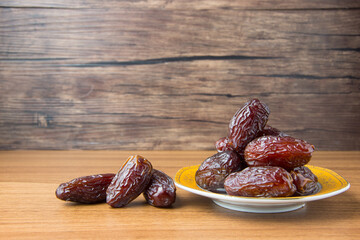 Delicious medjool dates ( kurma ) or sweet dried dates on a plate, as a meal for breaking the fast, ramadan kareem, empty space, copy space.