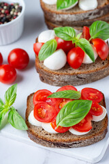 Fototapeta na wymiar Bruschetta with mozzarella, tomatoes and basil. Vegetarian food. Healthy eating