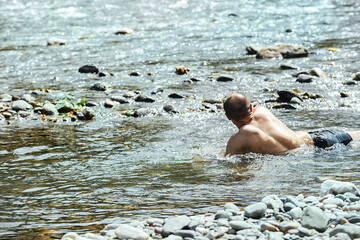 male tourist bathes in a mountain river