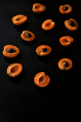 apricot halves with pits on a dark background with perspective view, focus on foreground