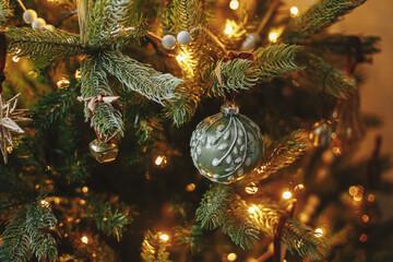 Christmas tree with vintage baubles and golden lights. Modern decorated christmas tree branches...