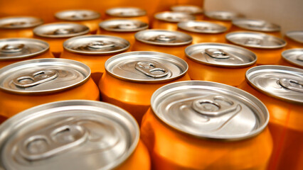 Close-up of many beautiful orange cans with soda or beer