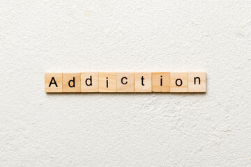 Addiction word written on wood block. Addictiontext on table, concept