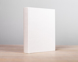 Book mockup standing at wooden table. Novel, encyclopedia, code template with blank cover. Reading...
