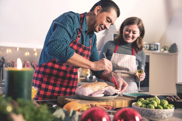 Happy man and woman cooking together traditional dinner for Christmas at home kitchen