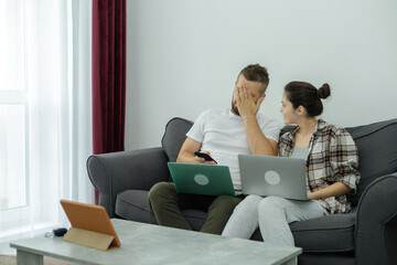 Couple at home doing online shopping with laptop