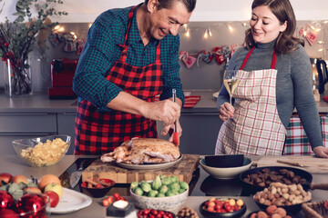 Happy man and woman cooking together traditional dinner for Christmas at home kitchen