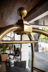 Luggage cart trolley at hotel lobby with male worker repainting hotel pillar in the background