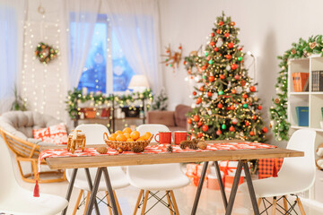 Christmas home room with Christmas tree and festive bokeh lighting, on background kitchen decorated...