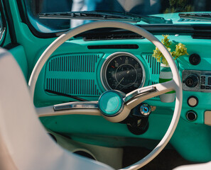  Vintage retro car interior steering wheel and dashboard. Retro green car interior view. The steering wheel is ivory.