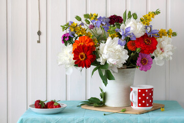 Summer still life with flowers and berries on the table.