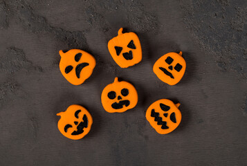 Halloween holiday. Themed creamy jelly candies in the shape of a pumpkin. Dark background. Top view