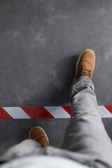 Man stepping over signal warning tape  at cement floor background. Moving forward  concept idea
