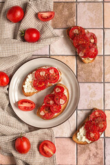 Bruschetta with cream cheese, tomatoes, garlic and olive oil on a kitchen ceramic surface. Cream cheese tomato toast for breakfast. Top view.