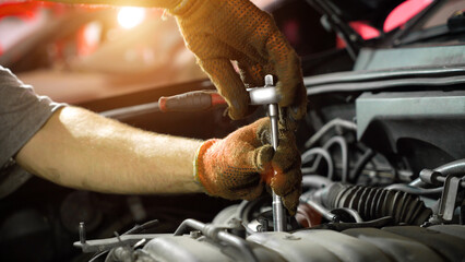 Auto mechanic repairs car engine. car service. auto repair shop. sunlight
