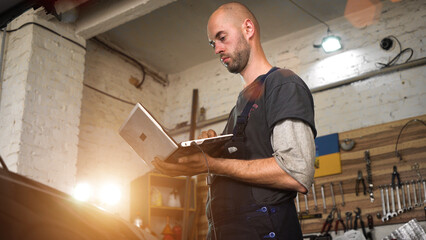 auto repairman diagnoses a car using a computer. car workshop. close-up