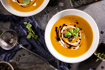 Pumpkin soup in a bowl with pumpkin seeds and croutons. fall dinner