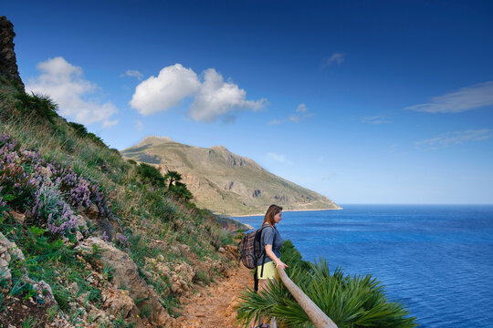 Young girl with a backpack on the trail at famous natural reserve Zingaro, province of Trapani, Sicily, Italy, Europe. Riserva naturale dello Z&iacute;ngaro, Sicilia, Italia