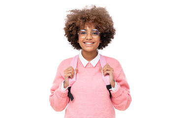 Studio portrait of smiling african american school girl or college student with curly afro hair and pink backpack, isolated