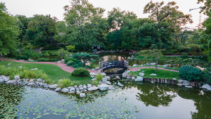 black woman with curly hair is happily walking around the beautiful nature park located in the city. as a tourist traveling to the destination is fun and peaceful 