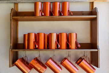 Olympia, Greece - July 19, 2022: Copper mugs on a shelf in Olympia, Greece
