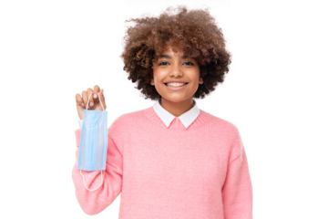 Portrait of smiling african american school girl holding face mask after the end of pandemic