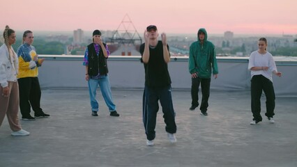 young people are dancing modern street dance on roof, breakdance and hip-hop choreography