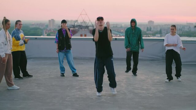 young people are dancing modern street dance on roof, breakdance and hip-hop choreography