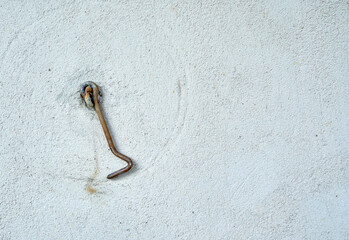 Metal old hook on wall of house with empty space for insertion.