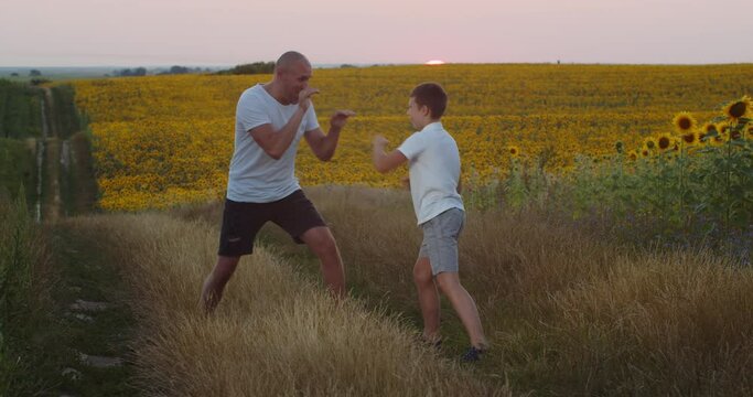Dad and his little son are training in the field