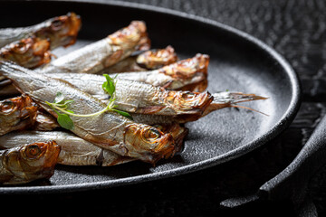Fresh smoked sprats with herbs and salt.