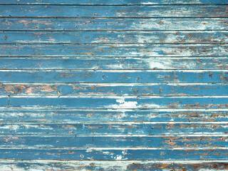 horiontal background consisting of wheathered old grungy blue planks with peeling paint