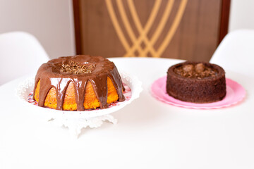 a carrot cake with chocolate frosting and a chocolate cake with brigadeiro frosting