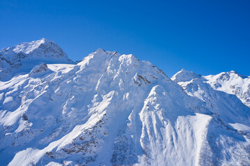Obraz premium Aerial view of snowy mountains on a sunny day