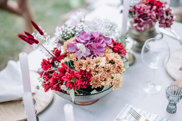 Modern wedding table decorated with plates, cutlery and flowers