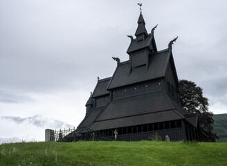 Fototapeta na wymiar Vik i Sogn, Norway - June 19, 2022: Hopperstad Stave Church is a historic parish church of the Church of Norway. Village of Vikoyri in Vik municipality. Vestland. Cloudy spring day. Selective focus